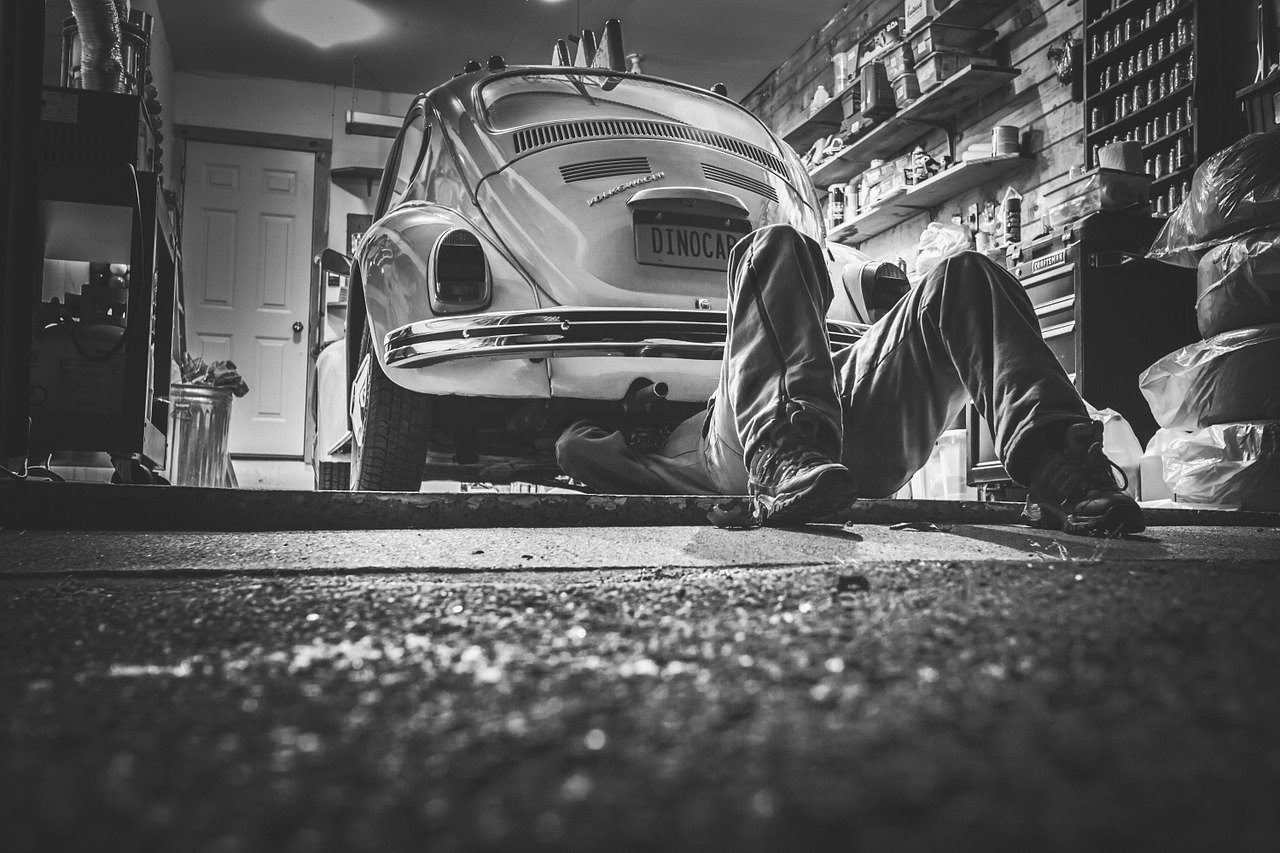 Automechanik opravuje historické vozidla Volkswagen Beetle.